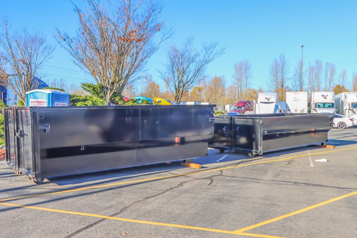 Professional dumpster rental service with roll-off container on residential driveway in Cuero